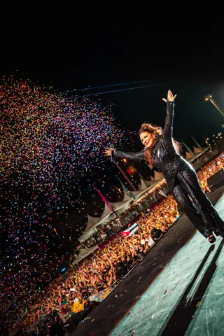 Gloria Estefan saluda con el brazo en alto ante el público bajo una lluvia de confeti. Gloria Estefan · Cook Music Fest, Tenerife, julio 2025