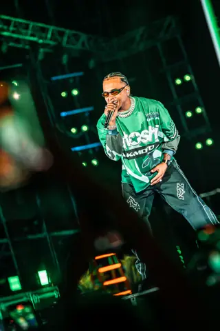 Ozuna canta de cerca con chaqueta verde bajo luz blanca. Why Agency Granca Live Fest Ozuna, Gran Canaria, julio 2025
