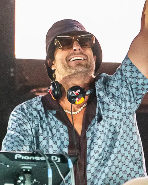 Fisher smiles and points skyward from the booth. Maudes Festival, Gran Canaria, July 2026.