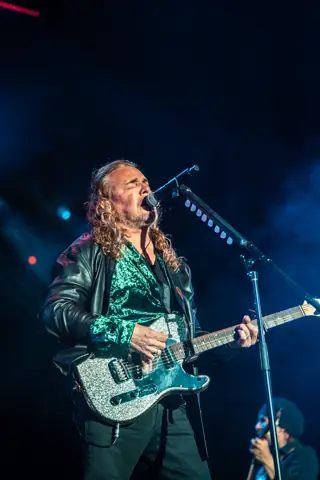 Fher, de Maná, canta con la guitarra bajo luz azul. Lava Live, Lanzarote, junio 2025. Foto para Why Agency.