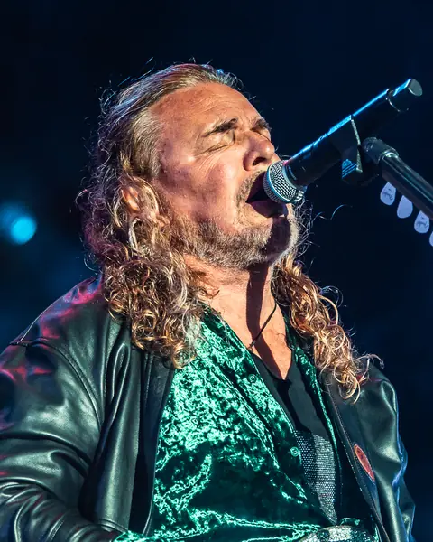 Fher of Maná sings with his guitar under blue light. Lava Live, Lanzarote, June 2025. Photo for Why Agency.