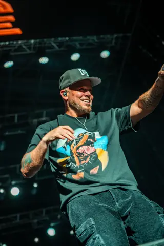 Residente, con gorra, canta señalando al público. Lava Live, Lanzarote, junio 2025. Foto para Why Agency.