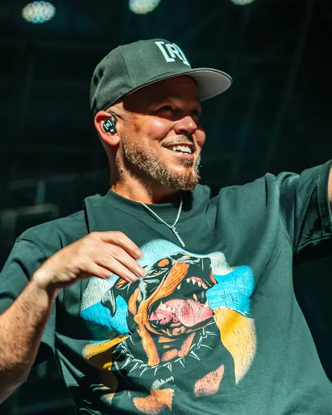 Residente, in a cap, sings pointing at the crowd. Lava Live, Lanzarote, June 2025. Photo for Why Agency.