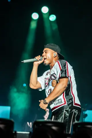 Myke Towers canta con gorra y camiseta de baloncesto. Cook Music Fest, Tenerife, julio 2026.