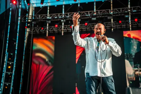 Óscar D'León saluda con el brazo en alto en el escenario. Cook Music Fest, Tenerife, julio 2025.