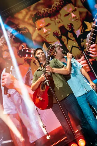 Los hermanos de Estopa con la guitarra bajo luz cálida. Lava Live, Lanzarote, julio 2025. Foto para Why Agency.