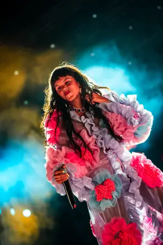 Li Saumet of Bomba Estéreo sings in a flower dress. Granca Live Fest, Gran Canaria, July 2025. Photo for Why Agency.