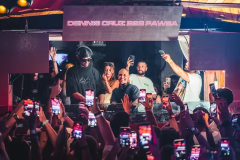 Booth with the Dennis Cruz b2b PAWSA sign and the crowd with phones. MAPPA 01 (Carry On), Tenerife, March 2024. Photo for Just Music.