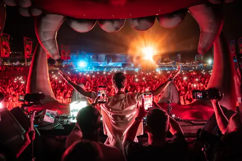 Wade from behind facing the crowd from the jaws of the elrow stage. elrow Tenerife XXL, October 2026. Photo for elrow.