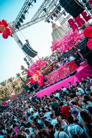 Escenario rosa con árboles en flor, flores gigantes y miles de personas. Bresh, Tenerife, septiembre 2025