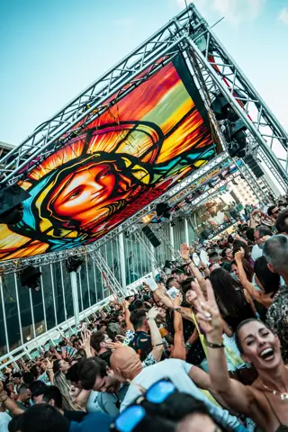 Público eufórico bajo una pantalla gigante con una Virgen de estilo pop. Brunch Nuestro, Tenerife, junio 2025