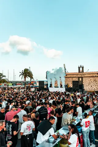 Multitud ante el escenario con CO2 junto al castillo de piedra. EMEC Lanzarote, mayo 2026
