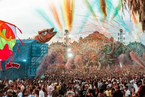 Cañones de confeti de colores sobre un público multitudinario y el escenario de elrow. elrow Tenerife XXL, octubre 2026