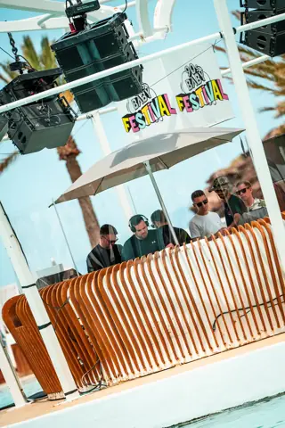 DJs en una cabina de madera con sombrilla junto a la piscina. 90s Baby, Tenerife, mayo 2025