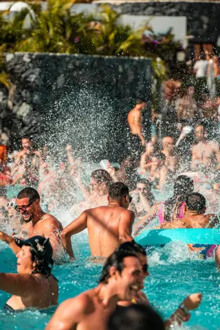 Salpicaduras y risas en una piscina llena junto a un muro volcánico. Lagoon Party, Tenerife, septiembre 2024