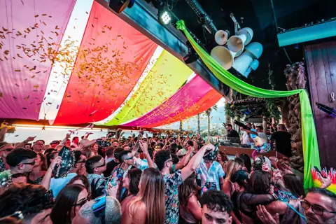 Confeti dorado bajo toldos de colores sobre la pista junto al mar. Monkey Beach Club, Tenerife, junio 2024