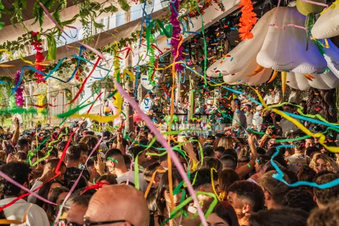 Serpentinas de colores y flores hinchables sobre la pista de día. Monkey Beach Club, Tenerife, junio 2024