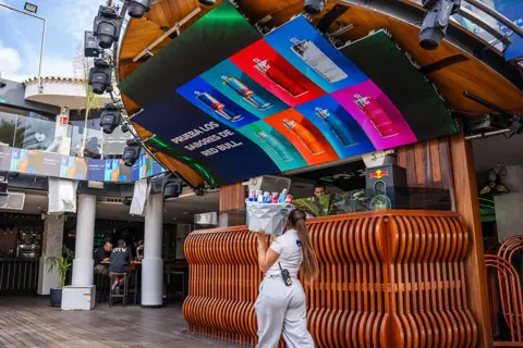 Pantalla curva con los sabores de Red Bull sobre la barra del club. Red Bull × Papagayo Beach Club, Tenerife, diciembre 2025